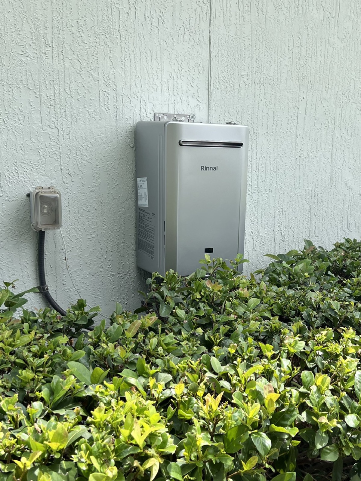 Rinnai outdoor tankless water heater installed on a Nassau County home exterior wall